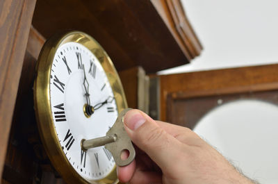 Close-up of hand holding clock