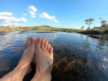 Low section of leg relaxing on lake