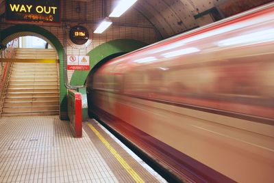 Blurred motion of train at illuminated railroad station