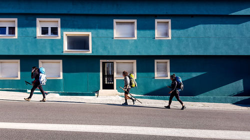 People walking on street against building