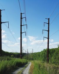 Electricity pylon on field against sky