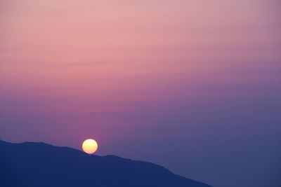 Scenic view of silhouette moon against sky at sunset