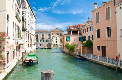 Boats in canal against buildings