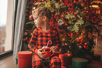 Happy little boy dreamer waiting at miracle santa enjoy sweets color lollipop. 