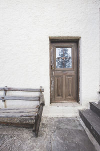 Empty bench by wall of building