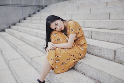 Portrait of young woman sitting on staircase