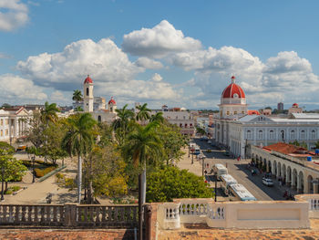 Palm trees with a church tower in the background in old town, cienfuegos, cuba