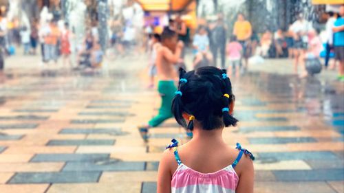 Rear view of girl standing on footpath