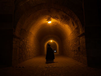 Rear view of man standing in tunnel