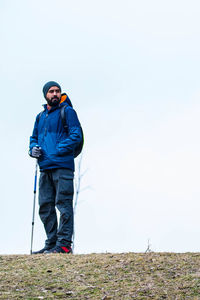 Full length of hiker standing on land against clear sky