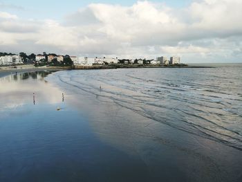 Scenic view of sea by buildings against sky