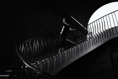 A pretty charming middle-aged woman in a black dress and sunglasses strolls through the stairs