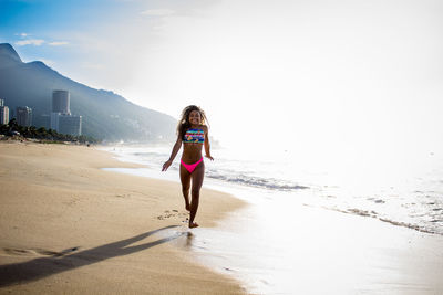 Full length of woman on beach against sky