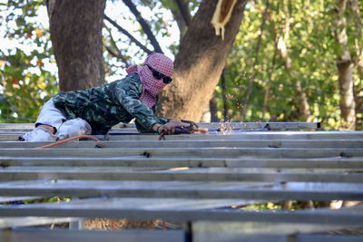 Low angle view of child on tree trunk