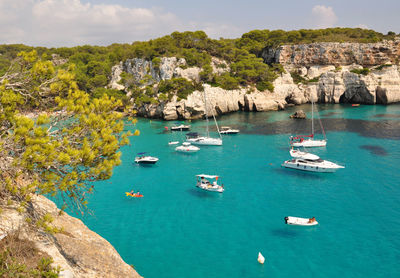 Boats in sea against rock formations