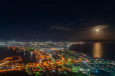 Hakodate city night view, big bright moon golden reflection light up the sea. hokkaido, japan
