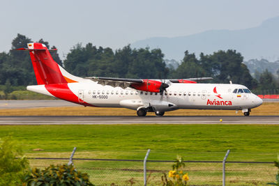 Airplane on airport runway against sky