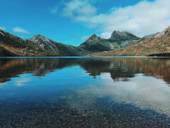 Scenic view of lake by mountains against sky