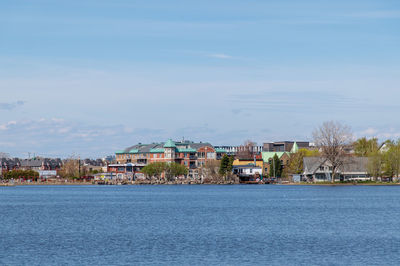 Houses by sea against sky in city