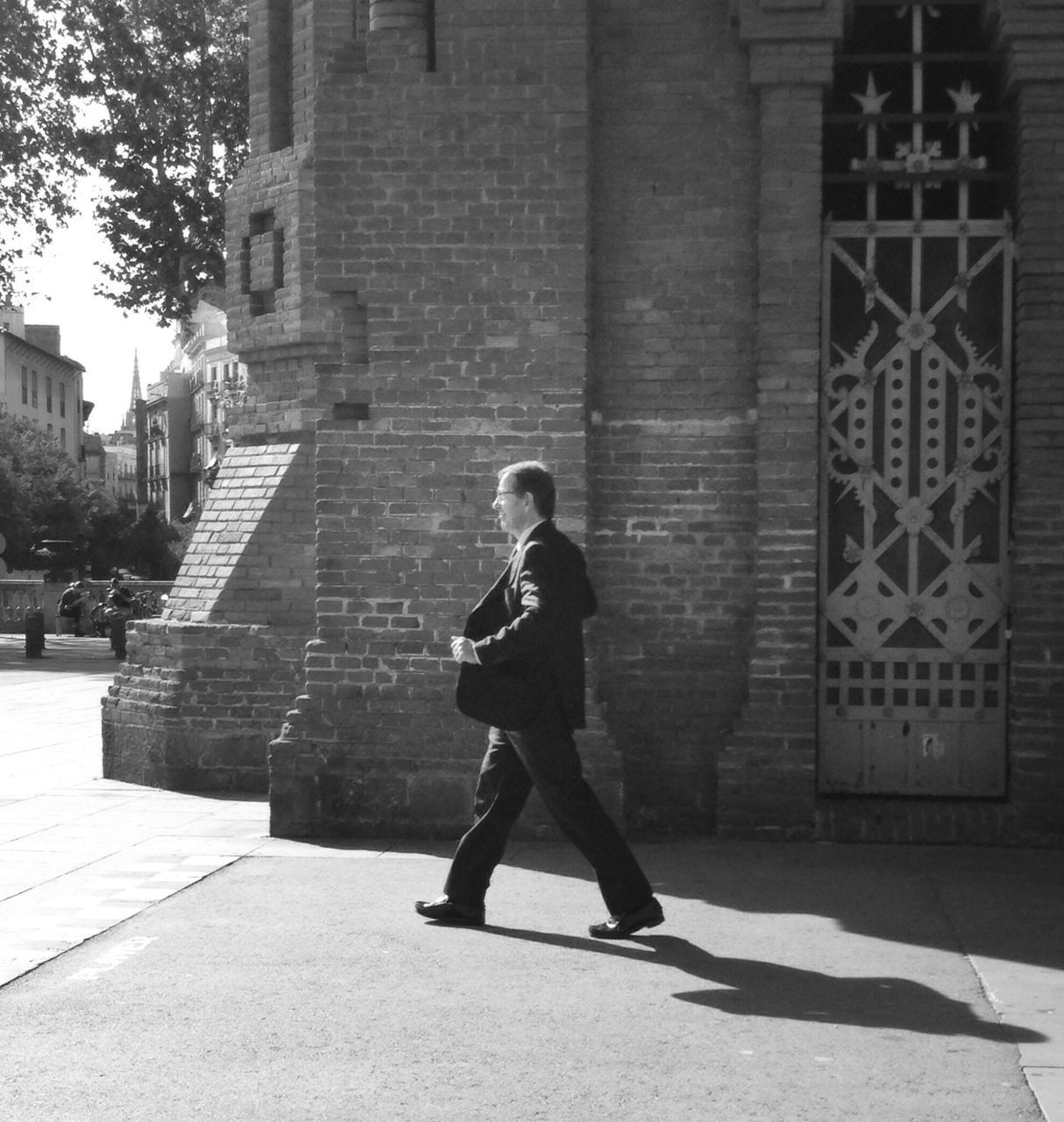 architecture, built structure, building exterior, lifestyles, full length, leisure activity, casual clothing, young adult, standing, steps, walking, wall - building feature, history, sunlight, shadow, brick wall, person, building