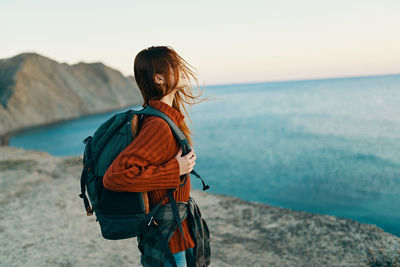 Woman looking at sea against sky