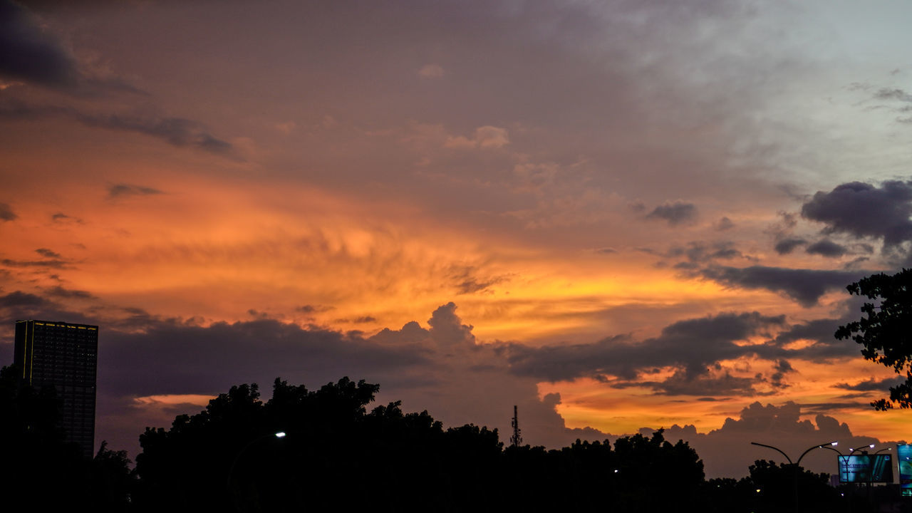 sky, cloud, sunset, afterglow, architecture, tree, silhouette, city, nature, dawn, evening, built structure, building exterior, horizon, beauty in nature, red sky at morning, building, dramatic sky, orange color, plant, landscape, no people, scenics - nature, outdoors, environment, cityscape, sun, tranquility, travel destinations, sunlight, cloudscape, urban skyline