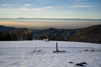 Scenic view of snowy field against sky during sunset