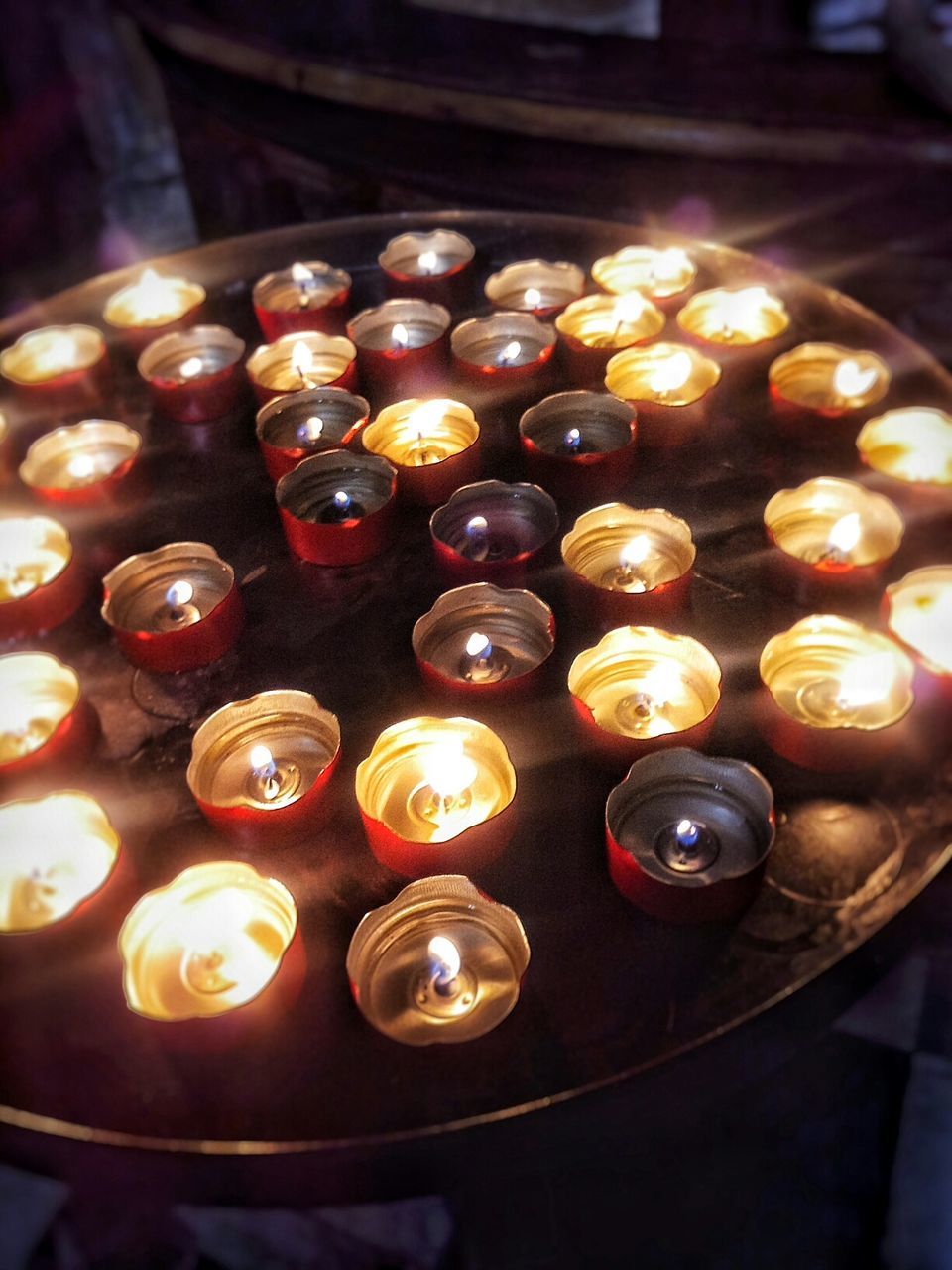 indoors, illuminated, food and drink, large group of objects, still life, candle, table, food, abundance, close-up, in a row, flame, heat - temperature, high angle view, burning, arrangement, glowing, no people, selective focus, wood - material