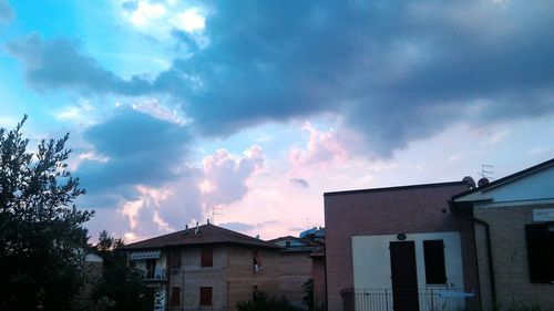 Low angle view of houses against cloudy sky