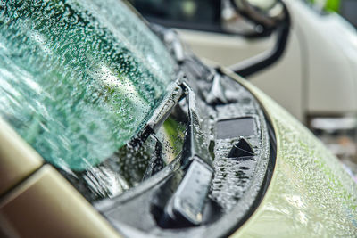 Close-up of wet side-view mirror