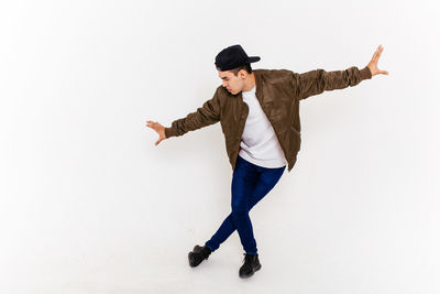 Full length of young woman standing against white background