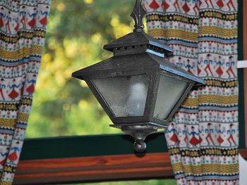 Close-up of electric lamp hanging outside building