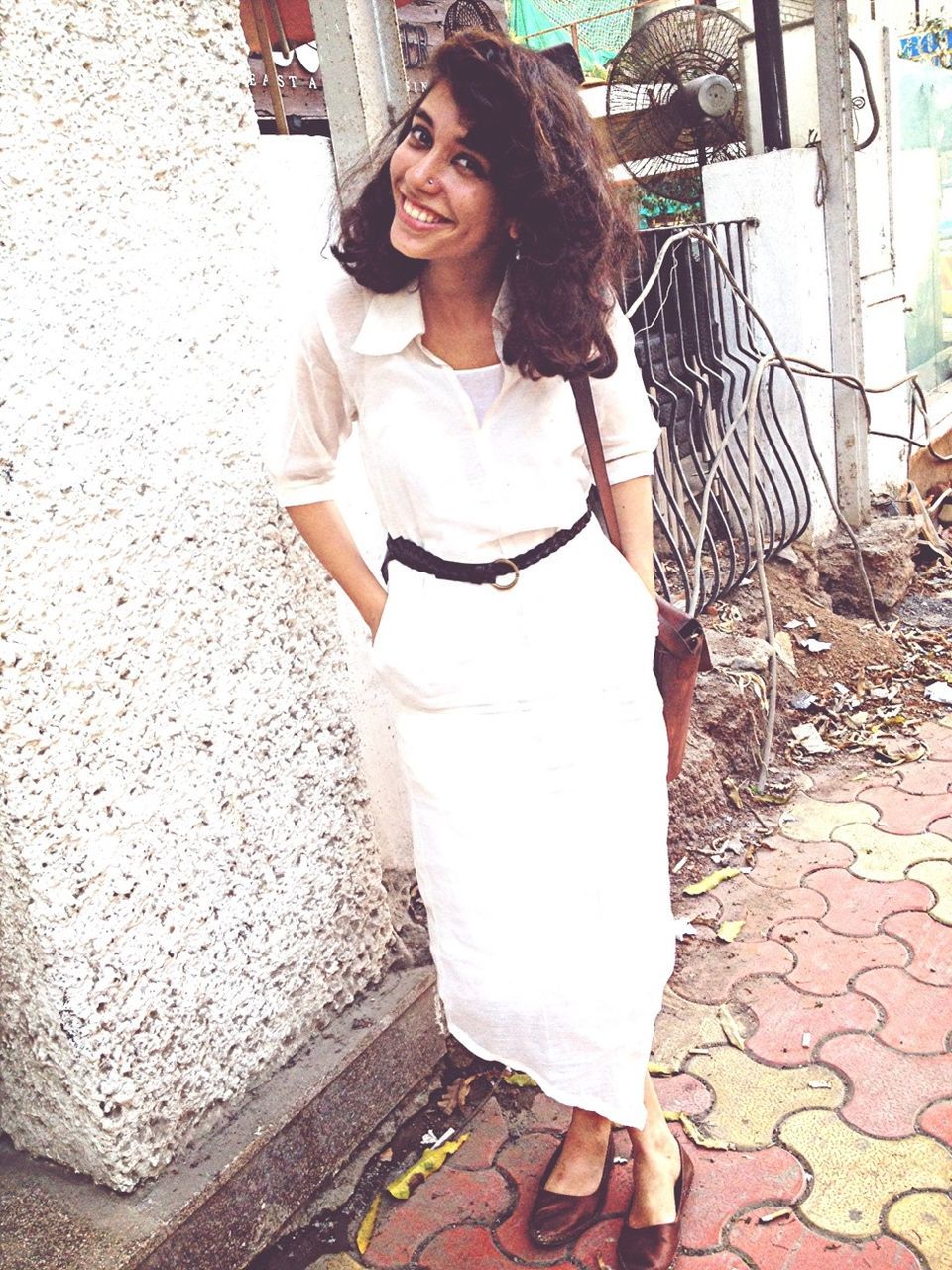 young adult, person, looking at camera, lifestyles, young women, portrait, casual clothing, front view, leisure activity, standing, smiling, architecture, built structure, sunglasses, full length, three quarter length, sitting