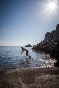 Man diving into sea against clear sky