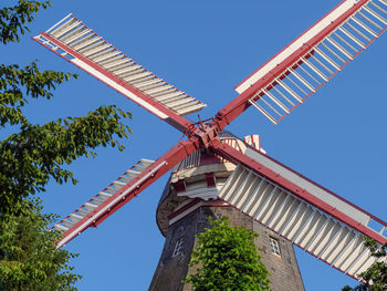 Low angle view of traditional windmill against clear blue sky