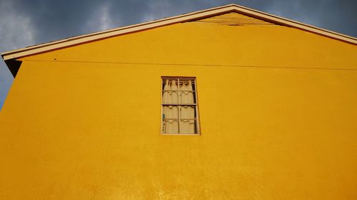 Low angle view of yellow building against sky