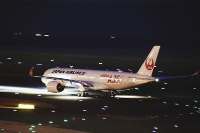 Low angle view of airplane against sky at night