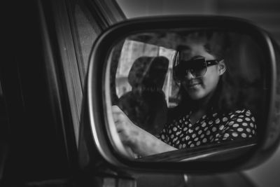 Reflection of man photographing in car mirror