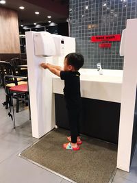 Side view of boy standing at home