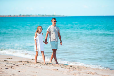 Full length of man standing at beach against sky