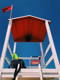 Low angle view of a lifeguard cabin against blue sky