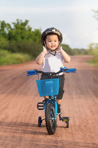 Boy riding bicycle on dirt road