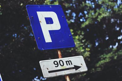 Low angle view of road sign against trees