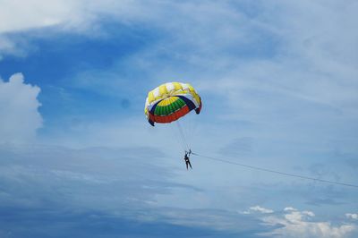 Low angle view of person paragliding against sky