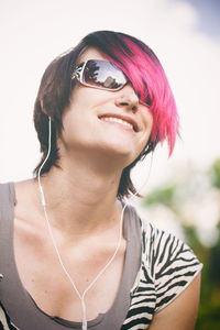 Portrait of smiling young woman against sky