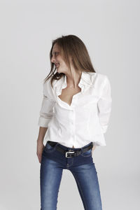 Young woman looking away against white background