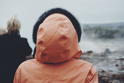 Rear view of people watching geyser