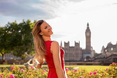 Smiling young woman standing against big ben