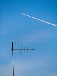 Low angle view of airplane flying against blue sky