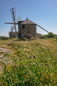 Traditional windmill on field against sky